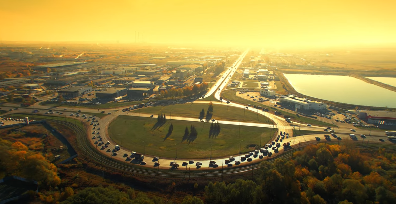 Verkehrskreisel bei Sonnenuntergang, Luftaufnahme der Stadt